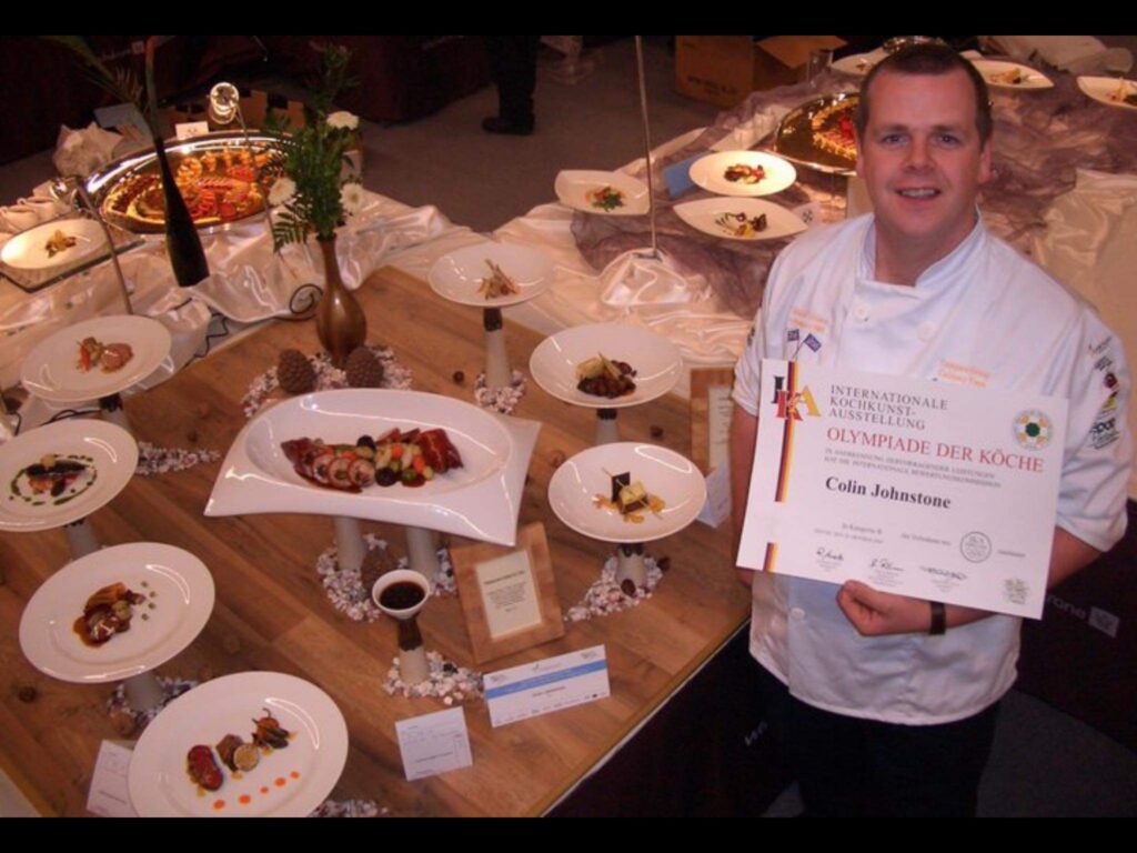 Colin holding award in front of food