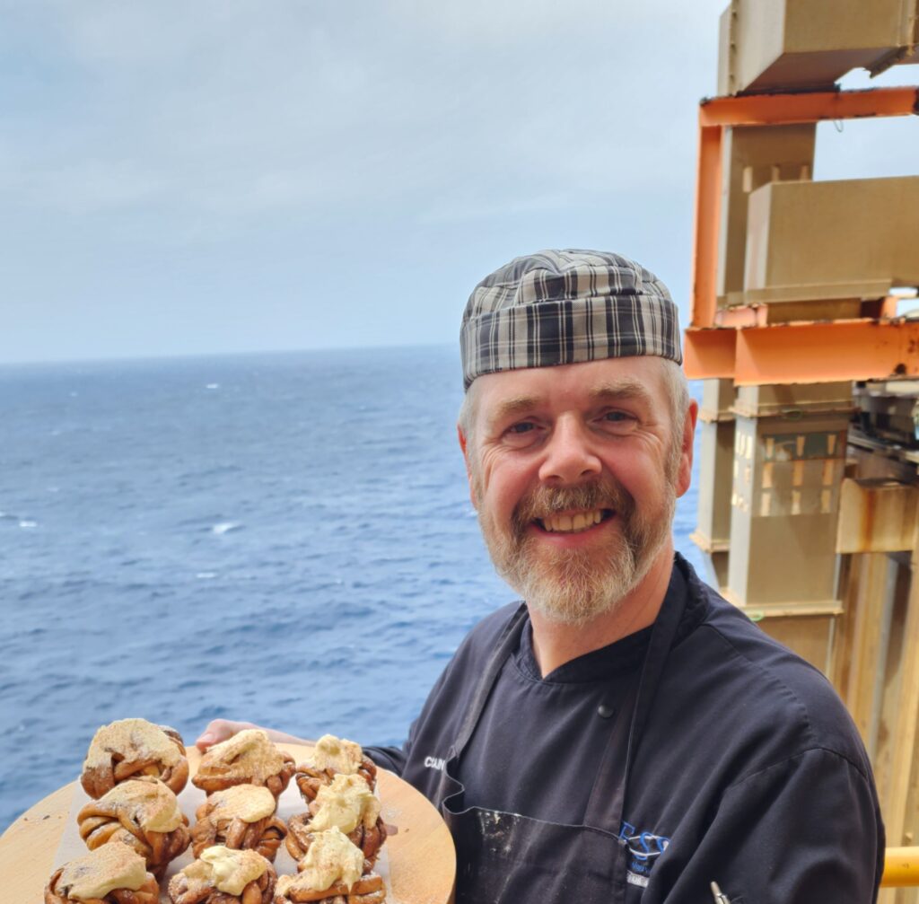 Colin holding a plate on muffins on site