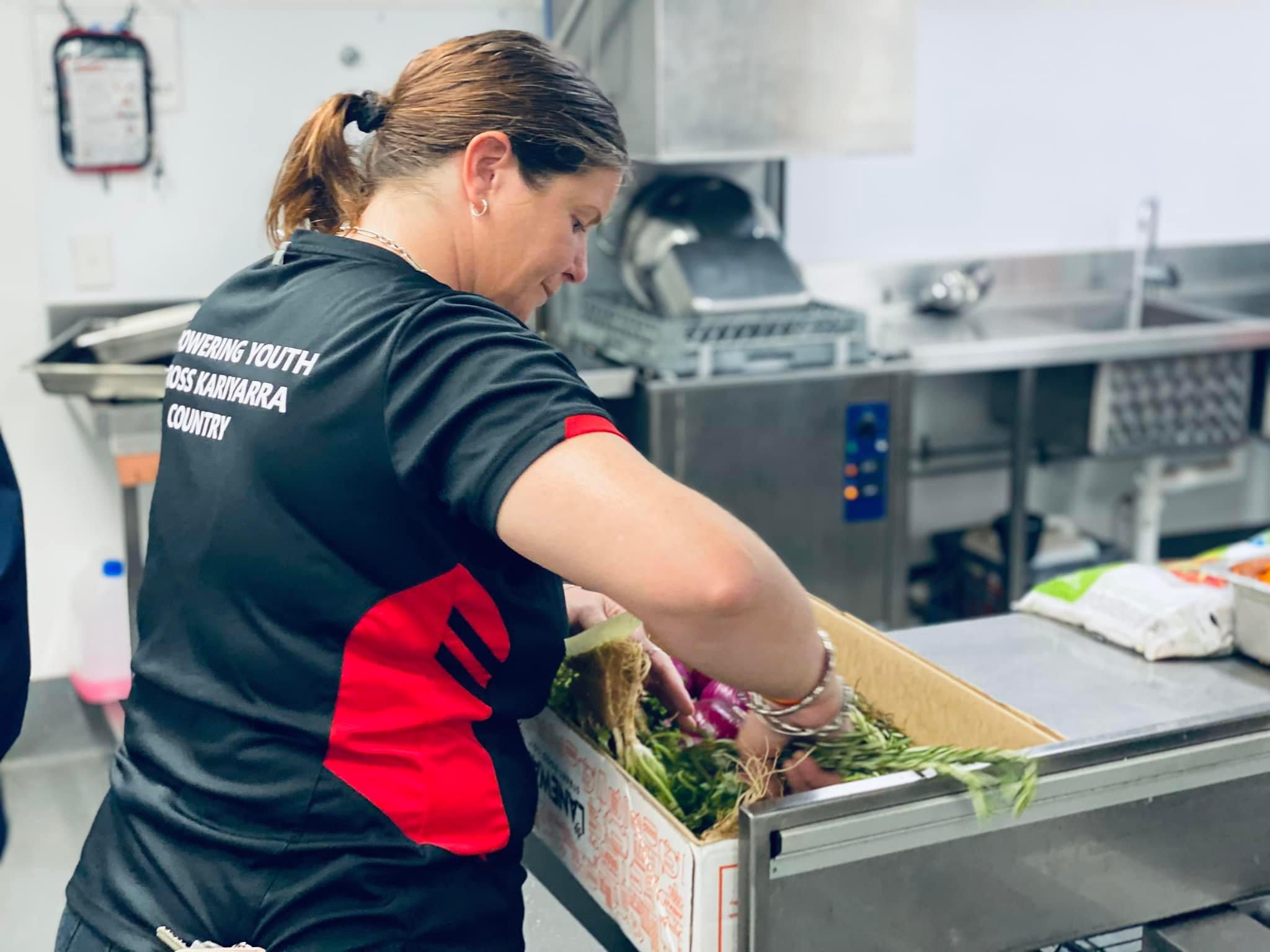 Nutritional Hunger Project team member in kitchen sorting ingredients